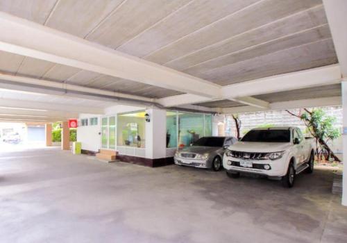 two cars parked in a parking lot at Grandview Ladprao Hotel in Bangkok