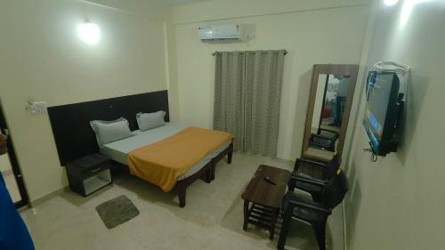 a bedroom with a bed and a mirror and a television at BILVA COMFORTs TUMKUR in Tumkūr