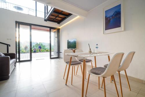 een woonkamer met een tafel, stoelen en een bank bij Naava Village in Tagalbato