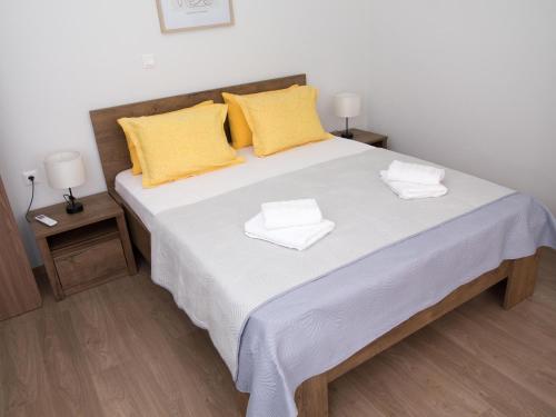 a bedroom with a large white bed with yellow pillows at Cozy apartment in Ialyssos in Ialyssos