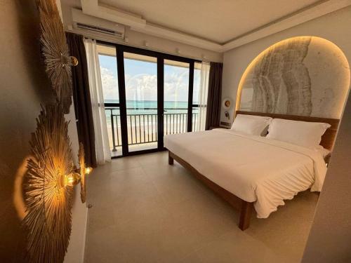 a bedroom with a bed and a view of the ocean at Coral Strand Smart Choice in Beau Vallon