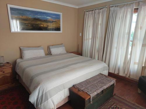 a bedroom with a bed and a painting on the wall at Tevreden in Rhodes