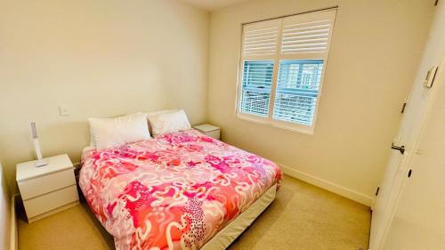a bedroom with a bed with a pink blanket and a window at Sydney Olympic Park 13Free Parking in Sydney