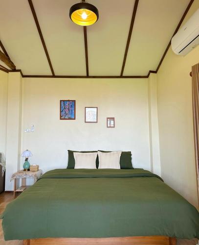 a bedroom with a large green bed in a room at Sayu Homestay&Cafe in Ban Pha Mi