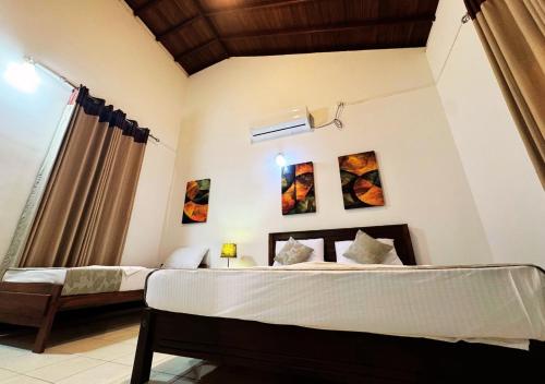 een slaapkamer met twee bedden en een raam bij Osara Holiday Home in Anuradhapura