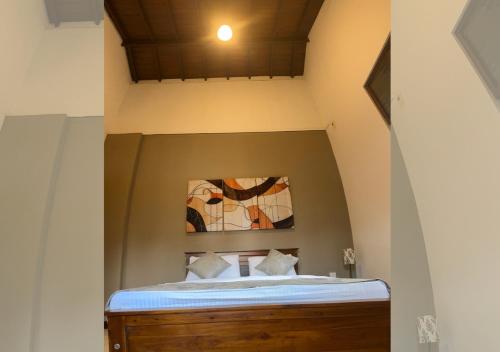 een bed in een kamer met een plafond bij Osara Holiday Home in Anuradhapura