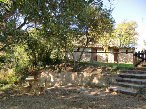 a picnic table and a bench in front of a building at Casa Rural Moixella in Lladurs