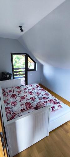 a white bed in a room with a window at Cabana Mămăruța in Bălceşti