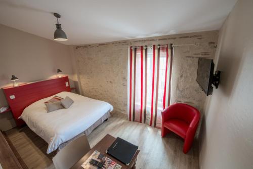 a small bedroom with a bed and a red chair at Logis Hotel Le Prince Noir in Sérignac-sur-Garonne