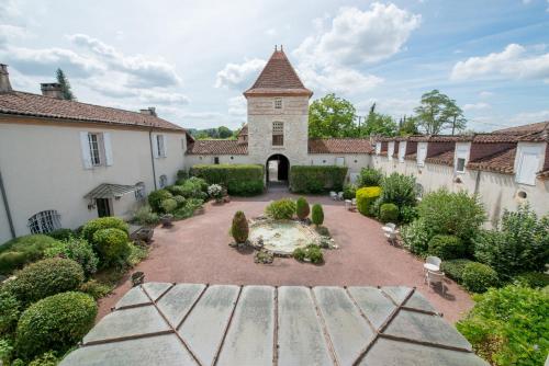 Sérignac-sur-GaronneにあるLogis Hotel Le Prince Noirの噴水のある中庭と建物