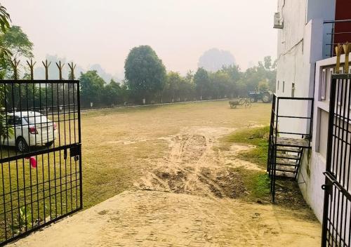 un terrain vague avec une voiture garée devant un bâtiment dans l'établissement Hotel ShivDham Naimisharanya, à Naimishāranya