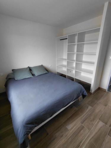 een slaapkamer met een bed en een boekenplank bij Gîte du champ aisé in Montaigu-Vendée