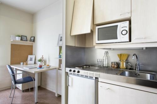 a kitchen with a sink and a microwave at Residencia Universitaria Blas De Otero in Bilbao