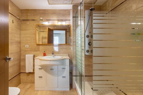 a bathroom with a sink and a mirror and a shower at Valencia Beach Vibe by Vireta Suites in Valencia