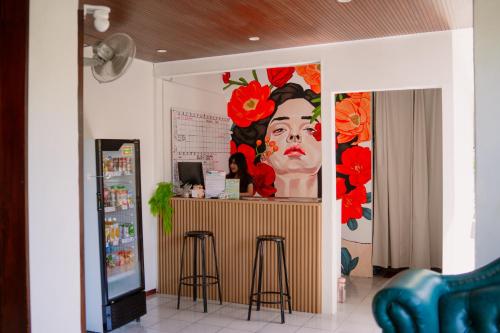 een kamer met een bar en een schilderij van een vrouw bij Snooze Malang in Malang