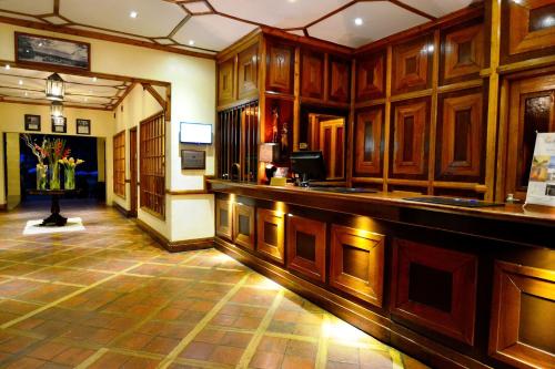 a large room with a bar with wooden cabinets at Muthu Lake Naivasha Country Club, Naivasha in Naivasha