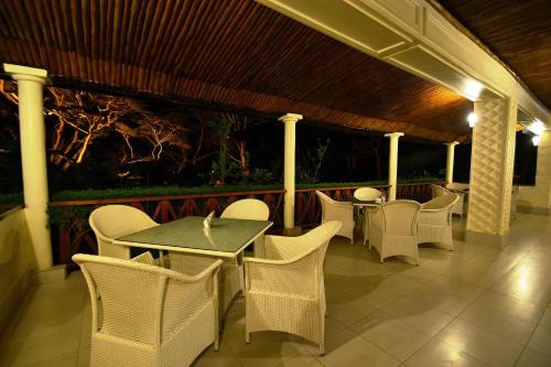 a patio with white chairs and tables and a wooden roof at Muthu Lake Naivasha Country Club, Naivasha in Naivasha