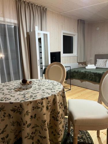 ein Zimmer mit einem Tisch und Stühlen und einem Bett in der Unterkunft Kulautuva Park Apartments in Kulautuva