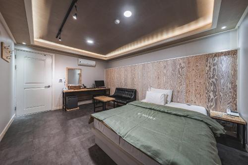 ein Schlafzimmer mit einem Bett und einem Schreibtisch in der Unterkunft V Hotel in Gumi