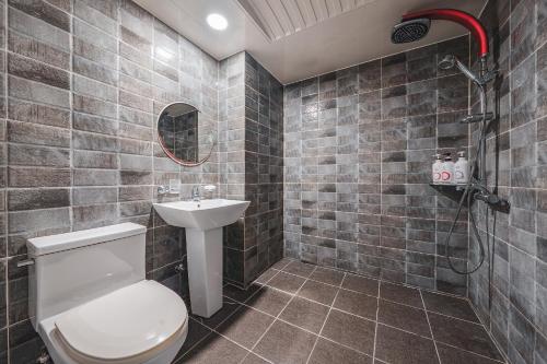 ein Badezimmer mit Toilette und Waschbecken in der Unterkunft V Hotel in Gumi