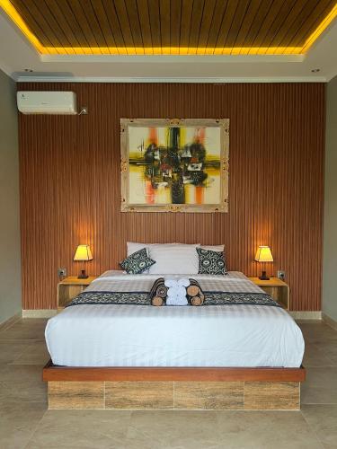 een slaapkamer met een groot wit bed met twee lampen bij Adiuma Cottage Ubud in Ubud