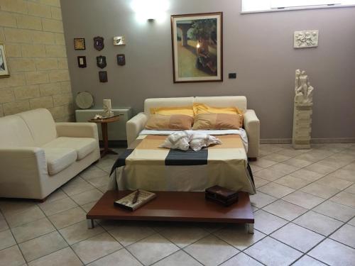 Villa Abati في Collepasso: غرفة نوم بسرير واريكة وطاولة