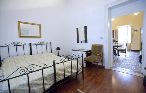 a bedroom with a bed and a desk and a chair at Casa Signorile in Trapani