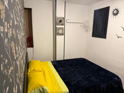 a bedroom with a bed with a yellow and black blanket at Loft Ohanes in Ohanes