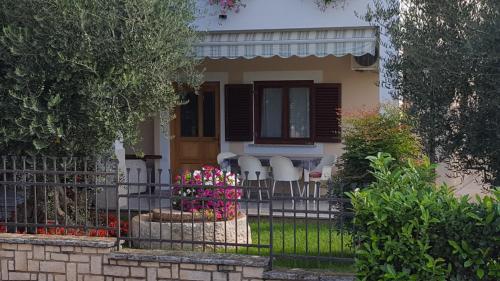 a fence in front of a house with chairs at Ulika Rooms & Apartments in Poreč