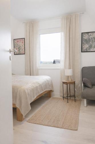a bedroom with a bed and a chair and a window at Ferienhaus Seeblick Westerwald in Mengerskirchen