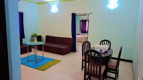 ein Wohnzimmer mit Sofa und Tisch in der Unterkunft Sai Dwarka Alibag Hotel in Alibag