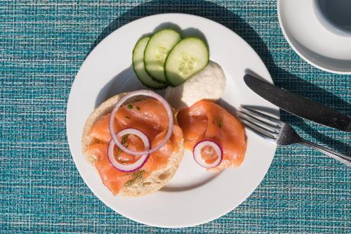 une assiette blanche avec un sandwich aux tomates et aux concombres dans l'établissement Hotel Haus am Meer, à Graal-Müritz