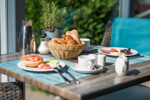 - une table avec des assiettes de viennoiseries et un panier de pain dans l'établissement Hotel Haus am Meer, à Graal-Müritz