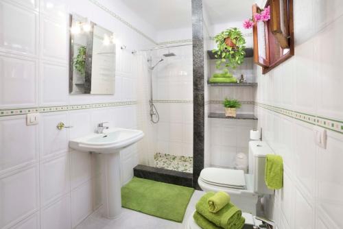a white bathroom with a sink and a toilet at Duplex Joan in Puerto del Carmen