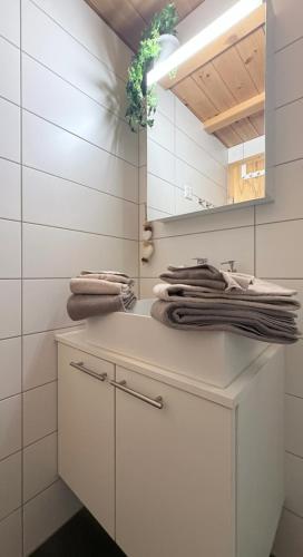 a white bathroom with a sink and a mirror at Bergquelle 1.OG Ost in Bettmeralp