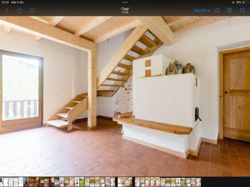 a room with a staircase and a white refrigerator at Alla Casetta B&B in Cesiomaggiore