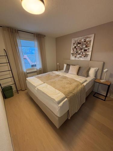 une chambre avec un grand lit et une fenêtre dans l'établissement Feel Home Apartments - Seeblick - Bergblick - Parkplatz, à Emmetten