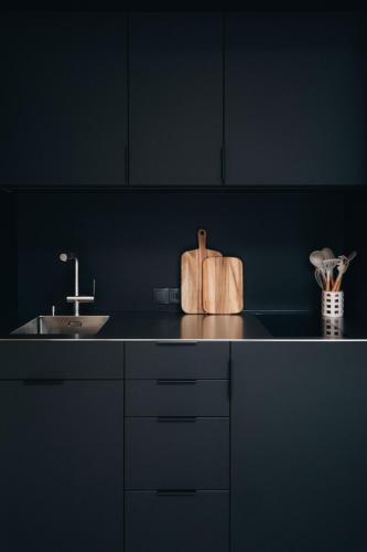 a black kitchen with a sink and a counter at Zalbander Chalets in Silbertal