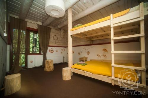 a bedroom with two bunk beds and two tables at Янтри in Dragobrat