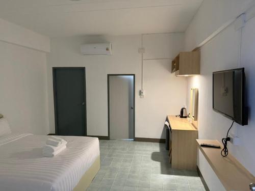 une chambre d'hôtel avec un lit et une télévision à écran plat dans l'établissement SLEEPLESS ROOM Phitsanulok, à Sathani Phitsanulok