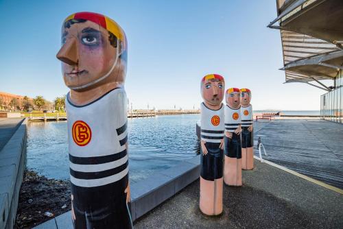 a row of fire hydrants sitting on top of a dock at Eastern Sands City Centre in Geelong