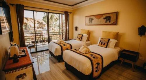 een hotelkamer met twee bedden en een raam bij Keep Diving Resort Bohol in Taporok