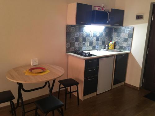 a small kitchen with a small table and a sink at Studio Cosy MM in Tbilisi City