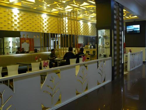 ein Restaurant mit Leuten, die an Tischen in einer Cafeteria sitzen in der Unterkunft V3 Hotel in Surabaya