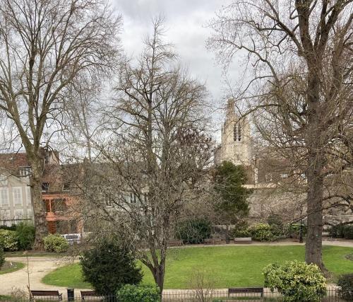 un parc avec des bancs en face d'une église dans l'établissement Logement à thème médiéval avec balneo, à Sens