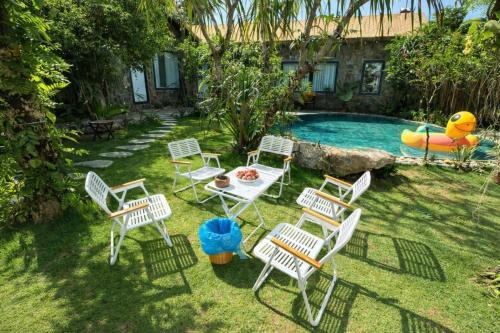 een groep stoelen en een tafel naast een zwembad bij Mộc Sơn Homestay in Mộc Châu