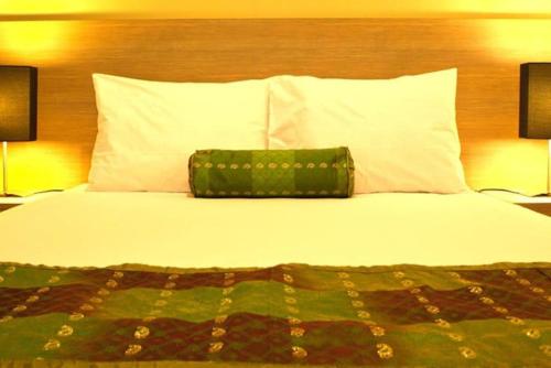 een bed met een groene tas bovenop bij Eazy Suite Legian in Legian