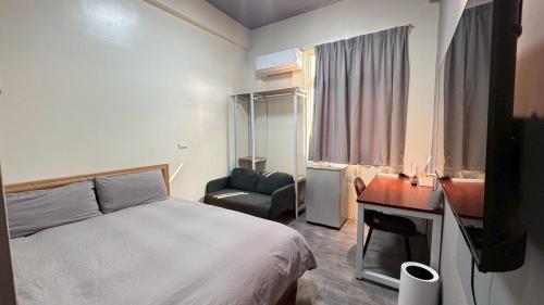 een slaapkamer met een bed, een bureau en een stoel bij 森林寓 Forest Inn in Minxiong