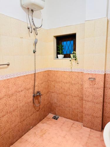 a shower in a bathroom with a window at Kandy Villa 119 in Kandy