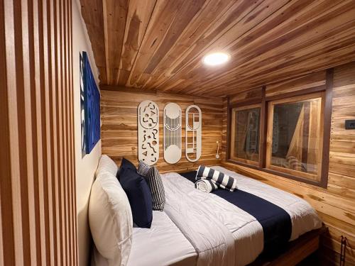 纳闽巴霍Phinisi Shared Boat Komodo的木屋里有一张床的卧室